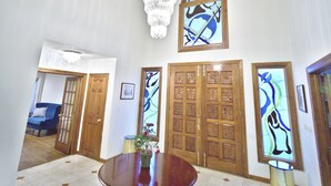 A spacious room with a round table, wooden doors, and a chandelier. - Nice Quiet Family Home (Potomac)