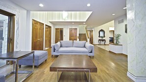 A spacious living room with a light blue sofa, a wooden coffee table, and a glass-top dining table. - Nice Quiet Family Home (Potomac)