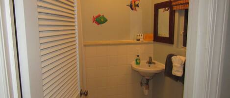 A bathroom with a sink, mirror, and decorative fish wall stickers.