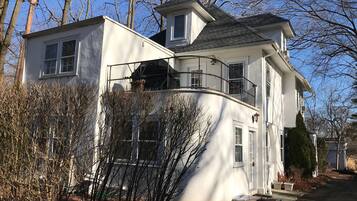 Two-story residence with a curved roofline and a balcony offering outdoor space.