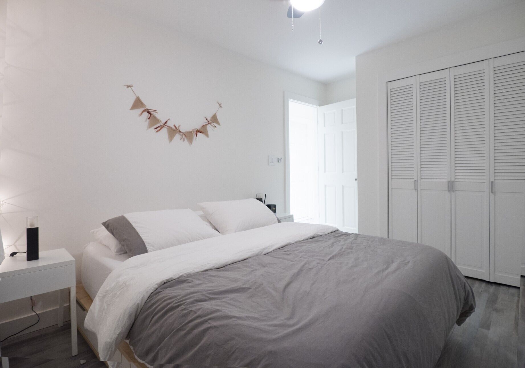Ein Schlafzimmer mit Bett, Nachttisch und Kleiderschrank.
