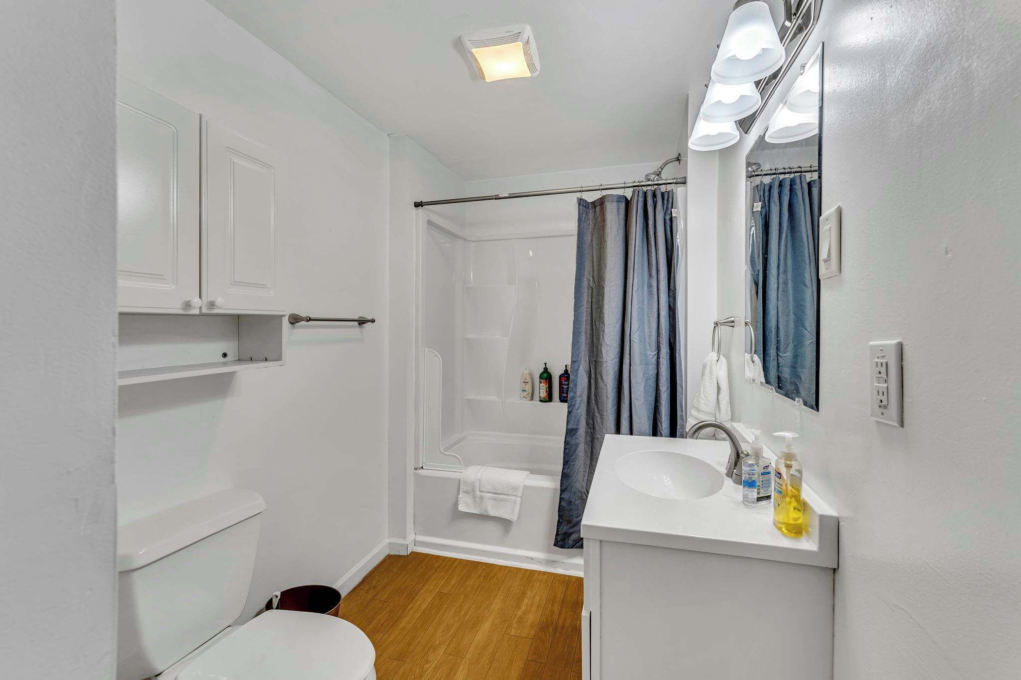 A bathroom with a shower, toilet, and sink.