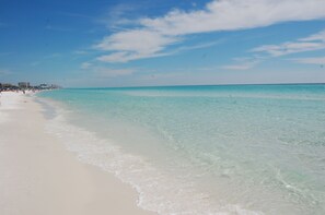 Una playa con aguas turquesas cristalinas y arena blanca.