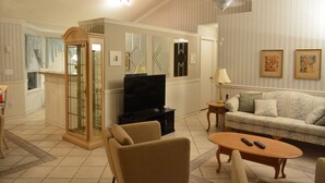 Un salon comprenant un canapé, une table basse, un téléviseur et un meuble.