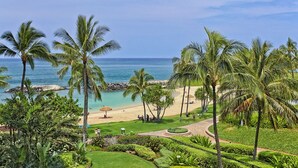Un complexe hôtelier tropical doté d’une plage, de palmiers et offrant une vue sur l’océan.