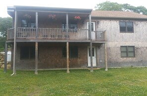 A two-story house with a balcony, a front door, and a small porch area.