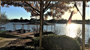 A lakeside pavilion with a view of the water, a dock, and a covered seating area.