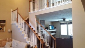 Interior de una casa con varios niveles, que incluye una escalera, una sala de estar y una cocina.