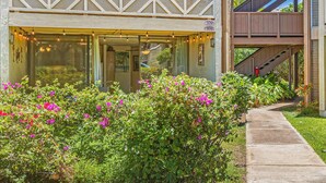 A building with a balcony, a visible address number, and a pathway leading to the entrance. - Tropical 2-BR Condo + Pool +  Hot Tub! 
CHECK OUT OUR SPRING 2026 SPECIALS (Kihei)