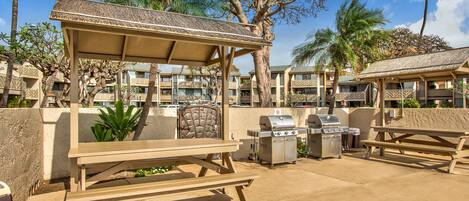 An outdoor patio area with a covered seating area, a barbecue grill, and a picnic table.