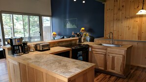 Una cocina con armarios de madera, una isla grande, una cafetera y un fregadero.