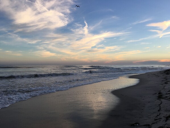 Ein Strand mit Wellen und einem klaren Himmel.