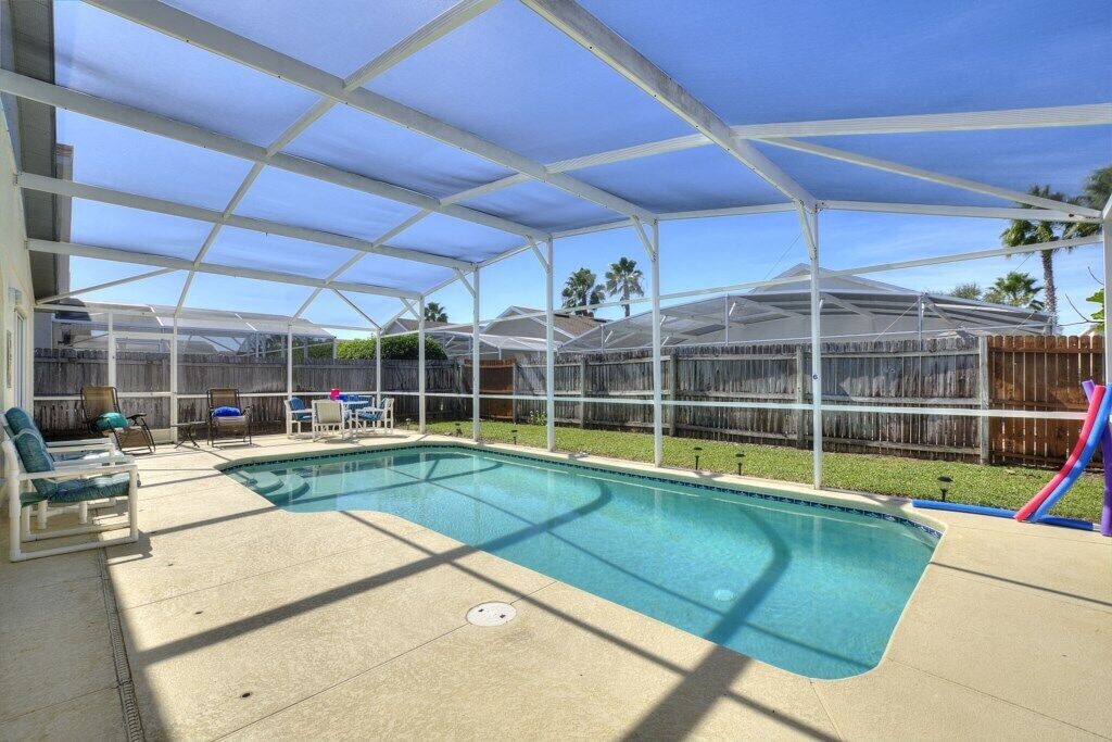 Un espace piscine couvert avec des chaises longues et un toboggan.
