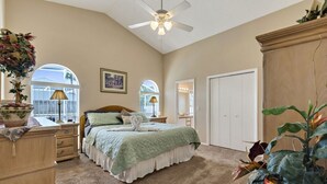 A bedroom with a bed, dresser, vanity, and a ceiling fan. - Minutes from Disney - Beautiful 3/2 Pool Villa with WiFi in Hampton Lakes  (Davenport)