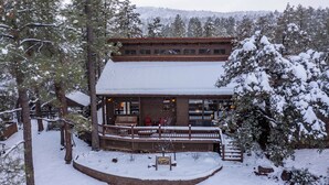 A lodge with a wooden exterior, a covered porch, and a sign in front. - Dancing Bear Lodge, Pine AZ; Luxury Cabin with Views, Spa & Outdoor living area (Pine)