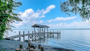 A wooden pier extending into calm water, with a covered shelter at the end.