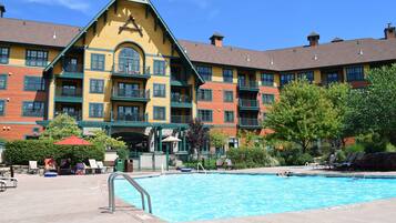 Ein Hotel mit Poolbereich, inklusive Schwimmbecken, Liegestühlen und Sonnenschirmen.