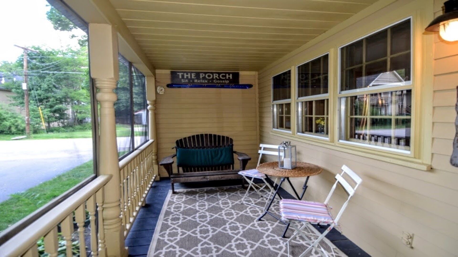 A porch with a sign reading "The Porch" and a small table with chairs.