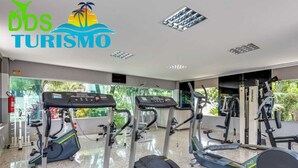 Un gimnasio con cintas de correr, elípticas y máquinas de pesas.
