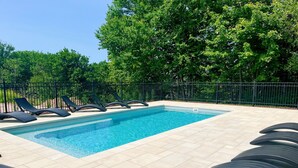 A rectangular swimming pool with clear blue water, surrounded by a tiled deck. - Hôtel Roquemont (Saint-Raymond)