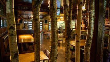 A cozy restaurant with wooden furniture and a warm ambiance, featuring a sign that reads "LE ROQUEMONT".