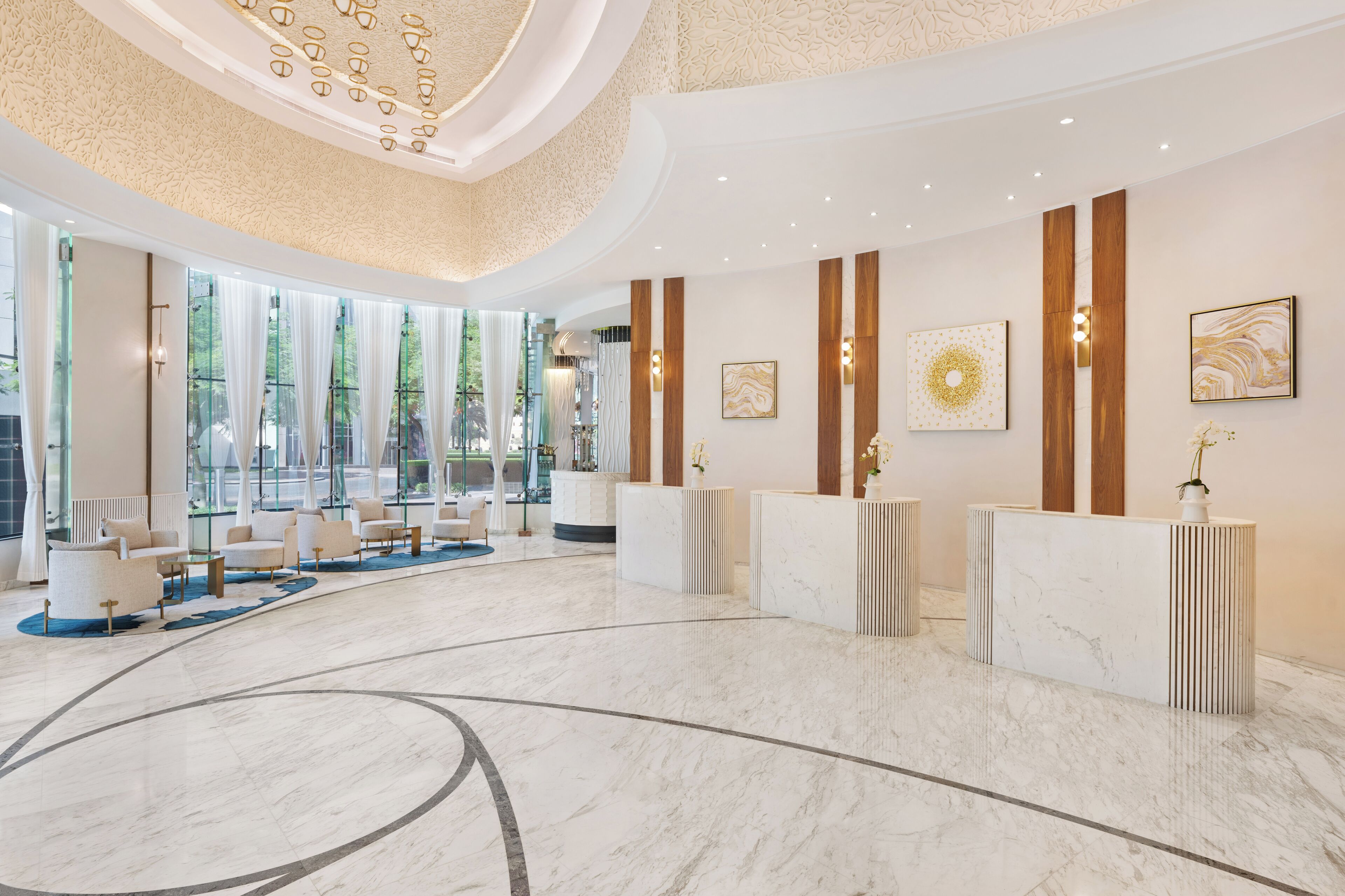 Un'ampia hall con pavimento in marmo, una reception e una zona salotto.
