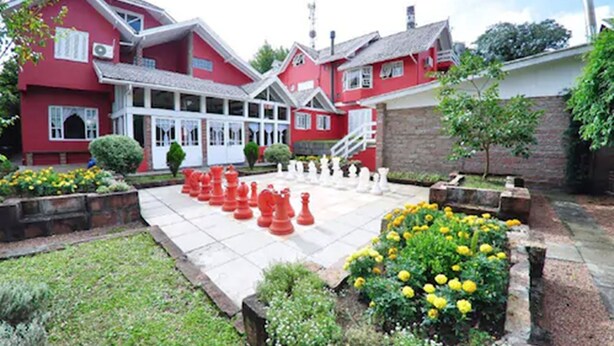 A red building with a garden chessboard. - Aardvark Inn Pousada (Gramado)