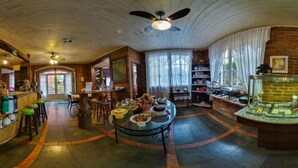 A spacious hotel lobby with a central dining area, a bar, and a buffet. - Aardvark Inn Pousada (Gramado)