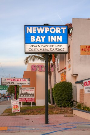 A sign for Newport Bay Inn, including the address and a nearby massage spa. - Newport Bay Inn (Costa Mesa)