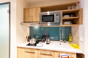 Una cocina moderna equipada con microondas, cafetera y hervidor.