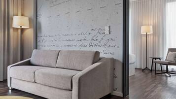 Una sala de estar moderna con un sofá beige, una pared grande con notas escritas a mano y dos lámparas de pie.