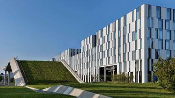 Ein modernes Gebäude mit einer markanten Fassade, einem geneigten Dach und einem gut sichtbaren Eingang, der „Stellaris Apartments Hotel“ ausweist.