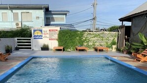 A rectangular swimming pool with a 3ft depth marker, surrounded by a white fence, wooden benches, and potted plants. - BAGOS ECO RETREAT & CAFE (Crown Point)