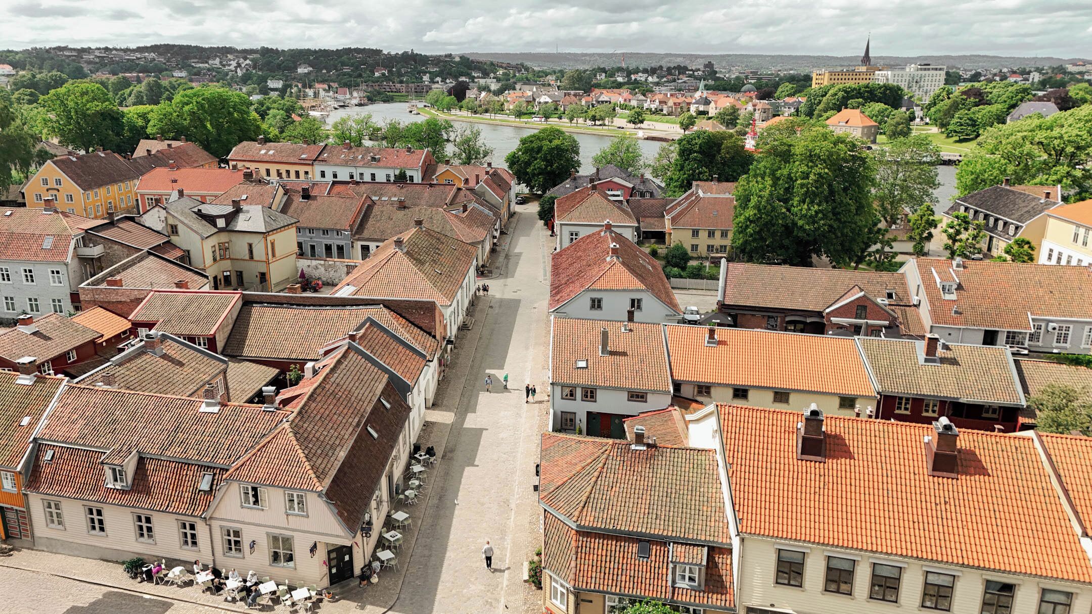A historic town with traditional architecture, cobblestone streets, and a river in the background.