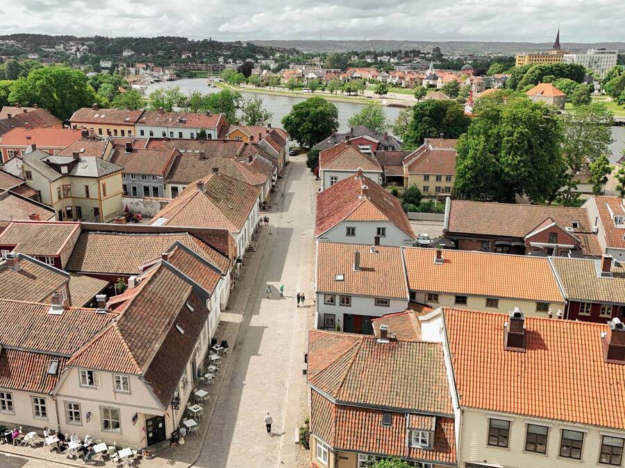 Un pueblo histórico con arquitectura tradicional, calles empedradas y un río al fondo.