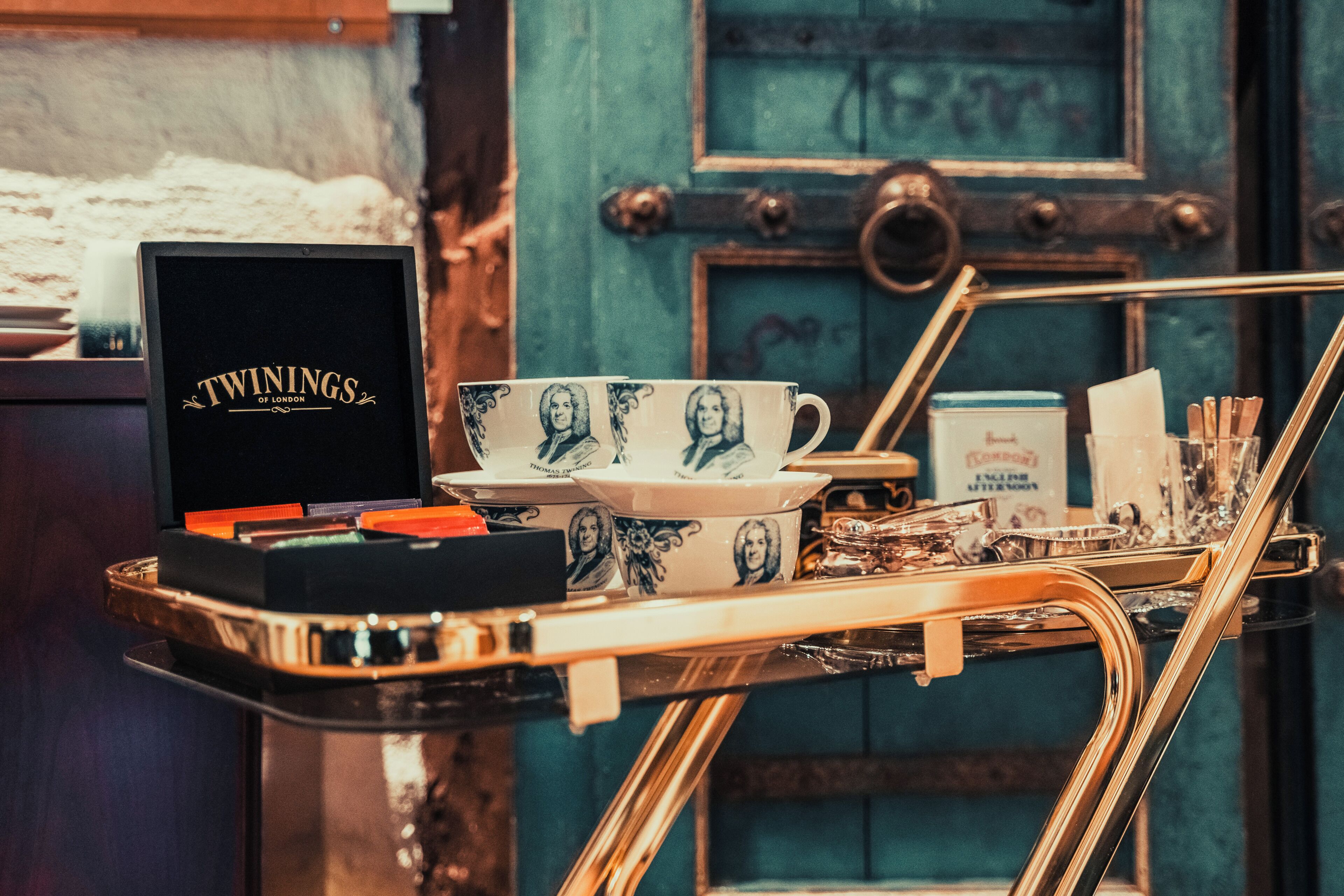 A tray with a box labeled 'TWININGS OF LONDON,' a set of cups, and a tray of tea and sugar.