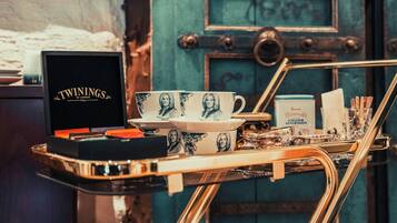 A tray with a box labeled 'TWININGS OF LONDON,' a set of cups, and a tray of tea and sugar.