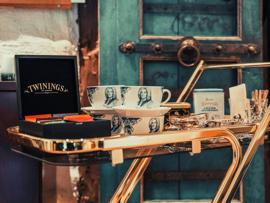 A tray with a box labeled 'TWININGS OF LONDON,' a set of cups, and a tray of tea and sugar.