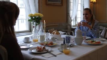 A dining table set with breakfast items, including eggs, toast, and fruit.