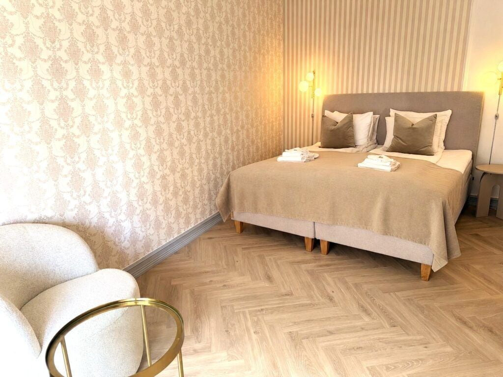 Une chambre d’hôtel avec un lit, une chaise et une lampe.