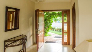 A hallway with a wooden door leading to a garden. - Well Furnished w Private Pool, BBQ & Palapa Bar (Sosúa)
