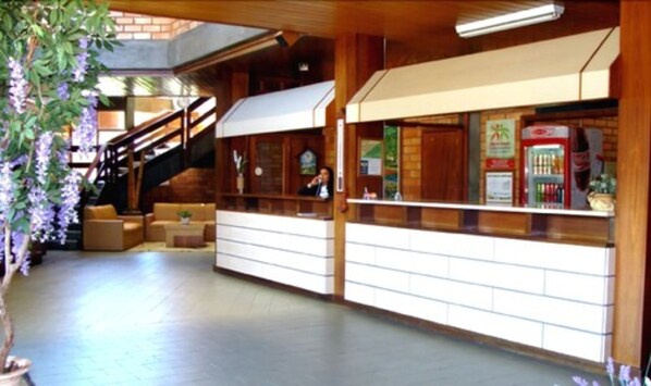 A lobby with a staircase, seating area, and a counter with vending machines.