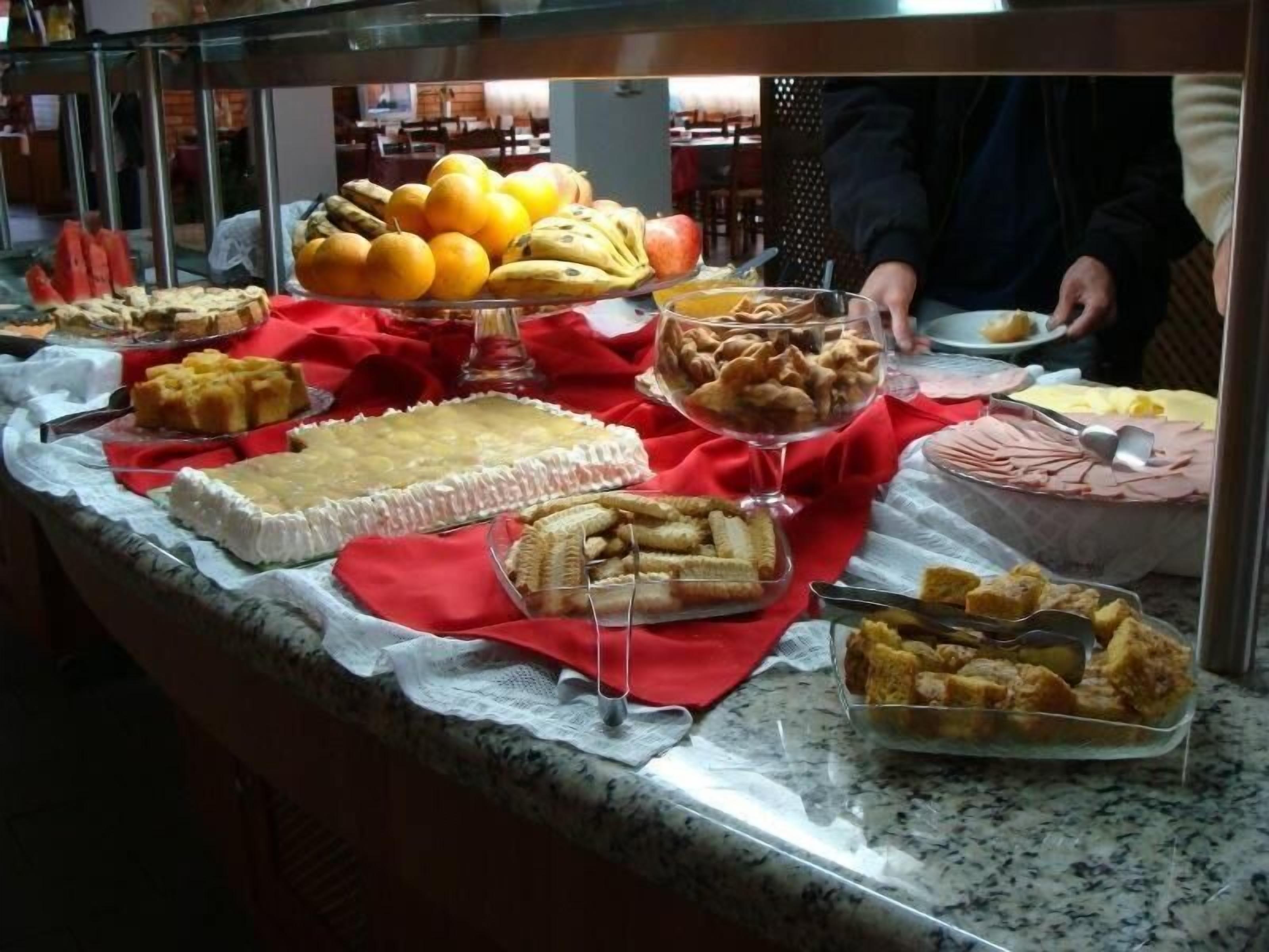Ein reichhaltiges Buffet mit verschiedenen Speisen, darunter Früchte, Desserts und Gebäck.