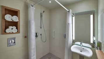 A modern bathroom with a glass shower enclosure, a wooden towel shelf, a sink, and a large mirror.