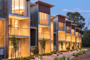 A modern hotel with multiple floors, large windows, and a well-maintained garden. - Maya Maya at Mandoon Estate (Caversham)