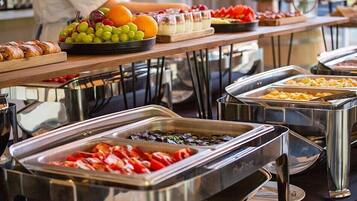 A buffet with various food items including fruits, vegetables, and prepared dishes.