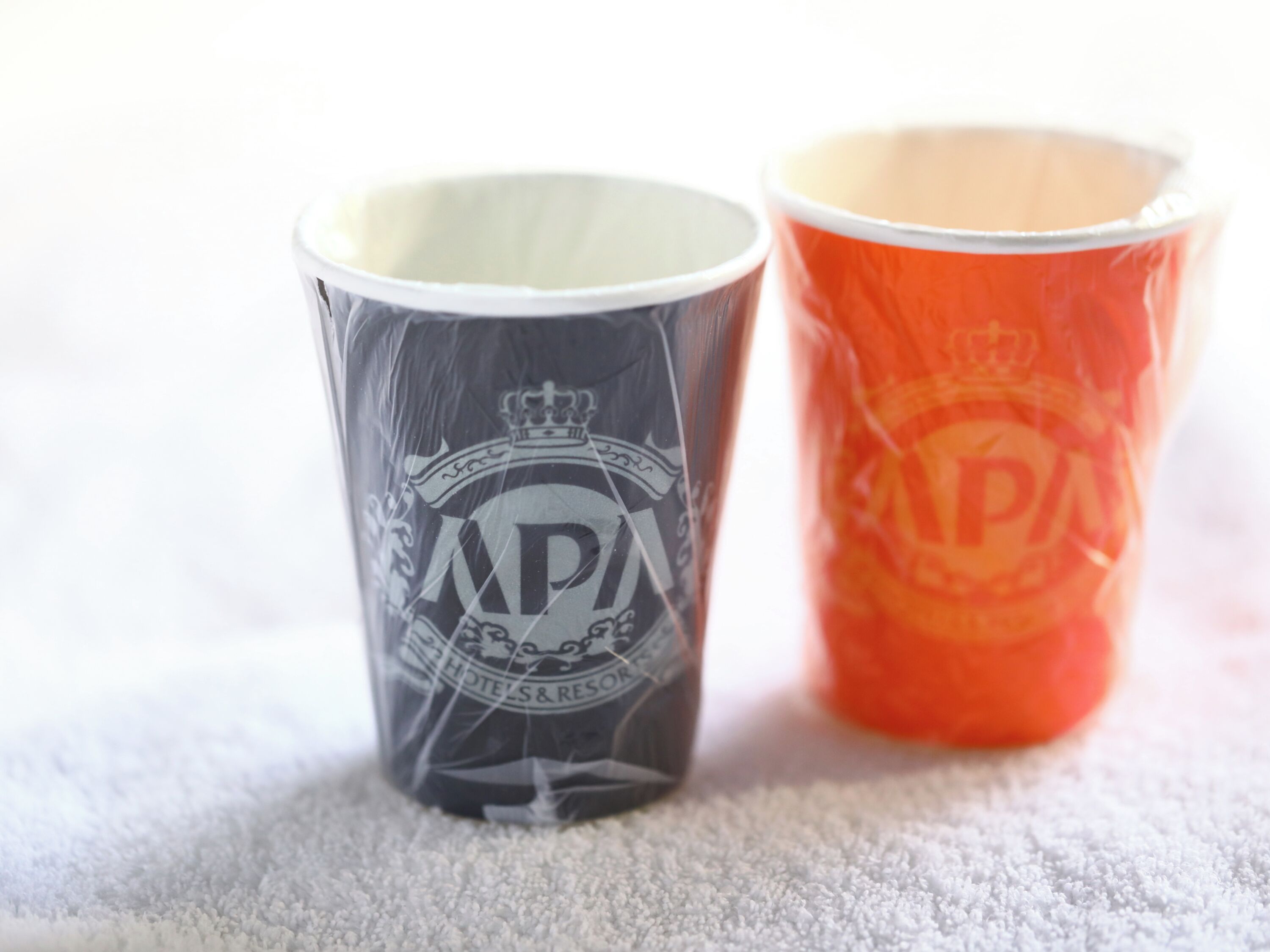 Two cups, one with a logo and text, the other with a logo and text.