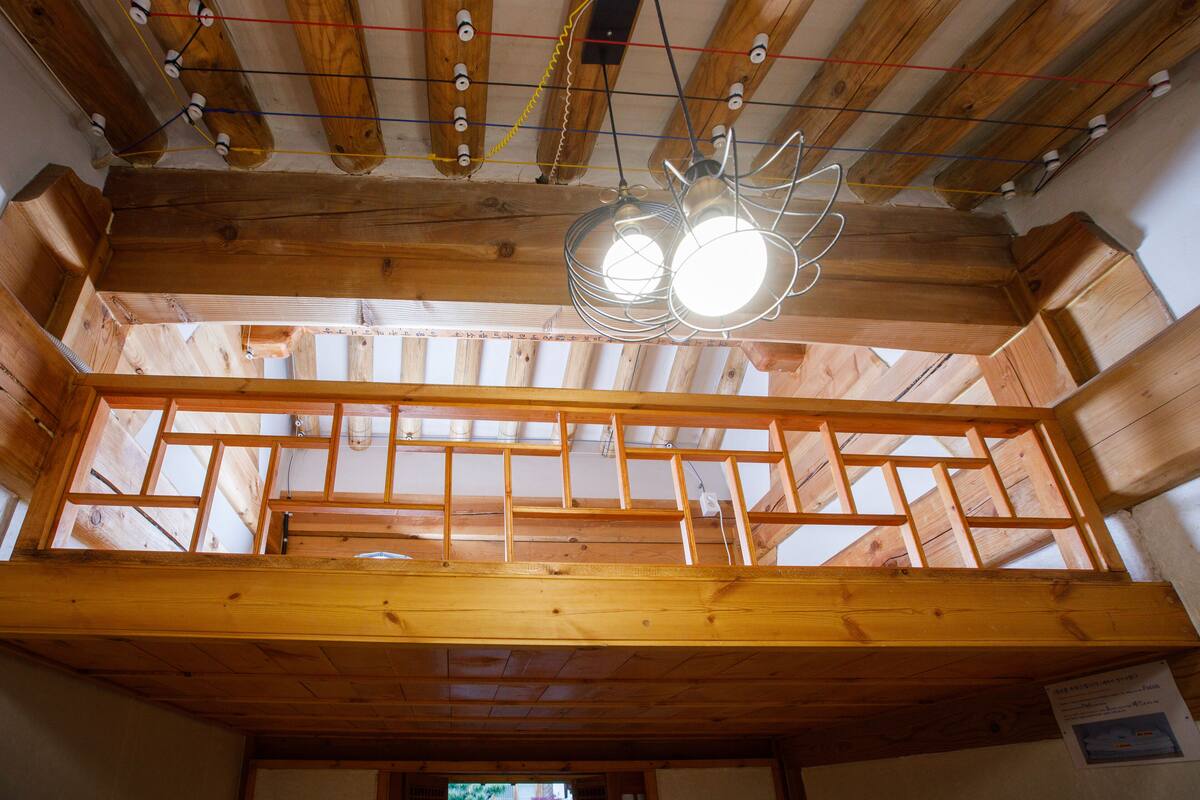 Un intérieur en bois avec des poutres apparentes et une lucarne.