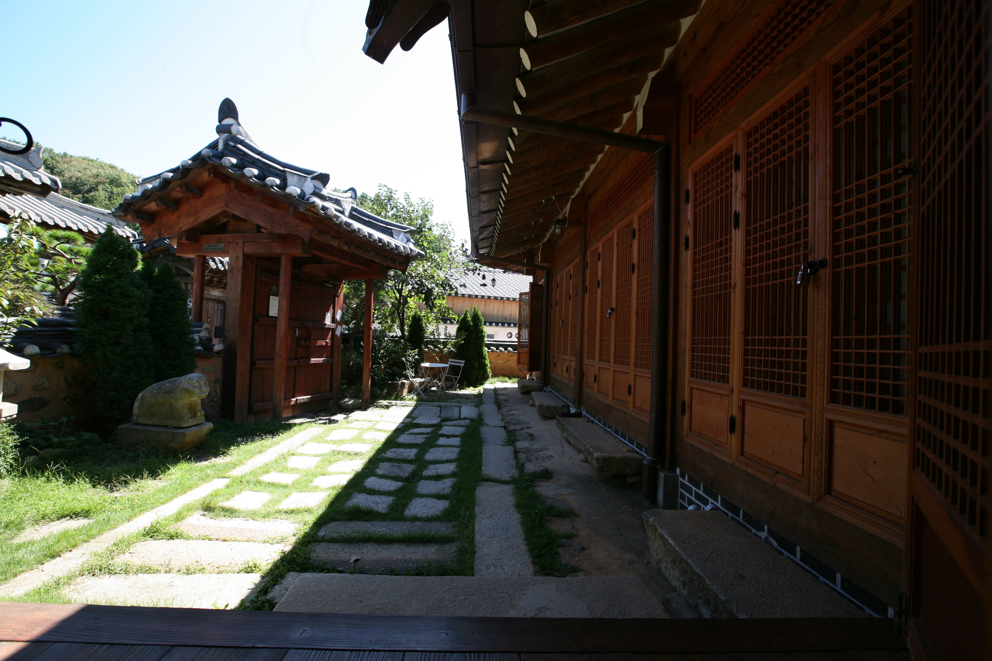 Un edificio tradicional japonés con un sendero de piedra que conduce a una puerta de madera.