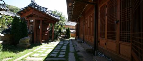 Un edificio tradicional japonés con un sendero de piedra que conduce a una puerta de madera.